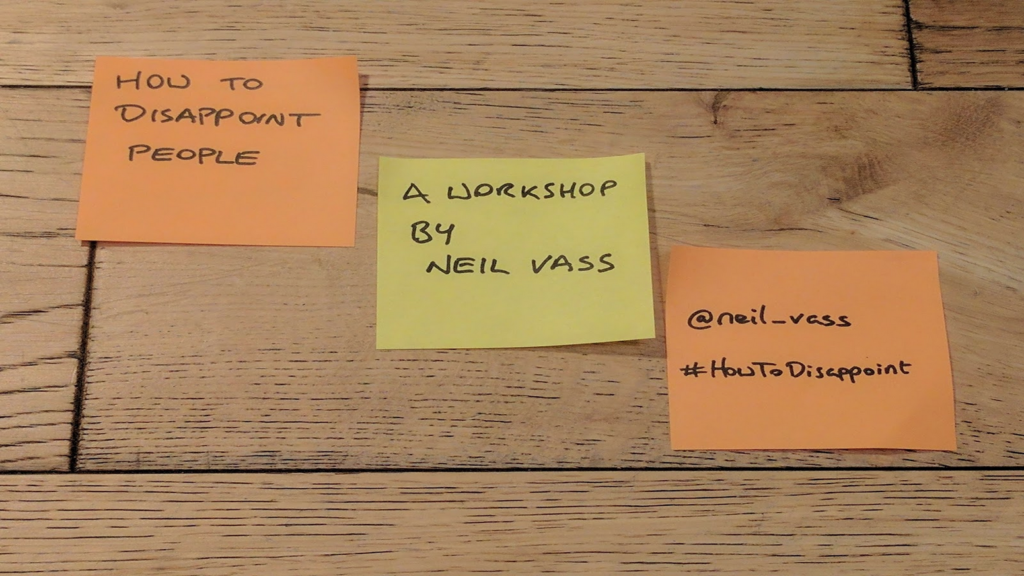 All the images in this series are slides from the workshop. This is a photo of 3 post-its on a wooden floor:

"How to disappoint people"
"A workshop by Neil Vass"
"@neil_vass #HowToDisappoint"