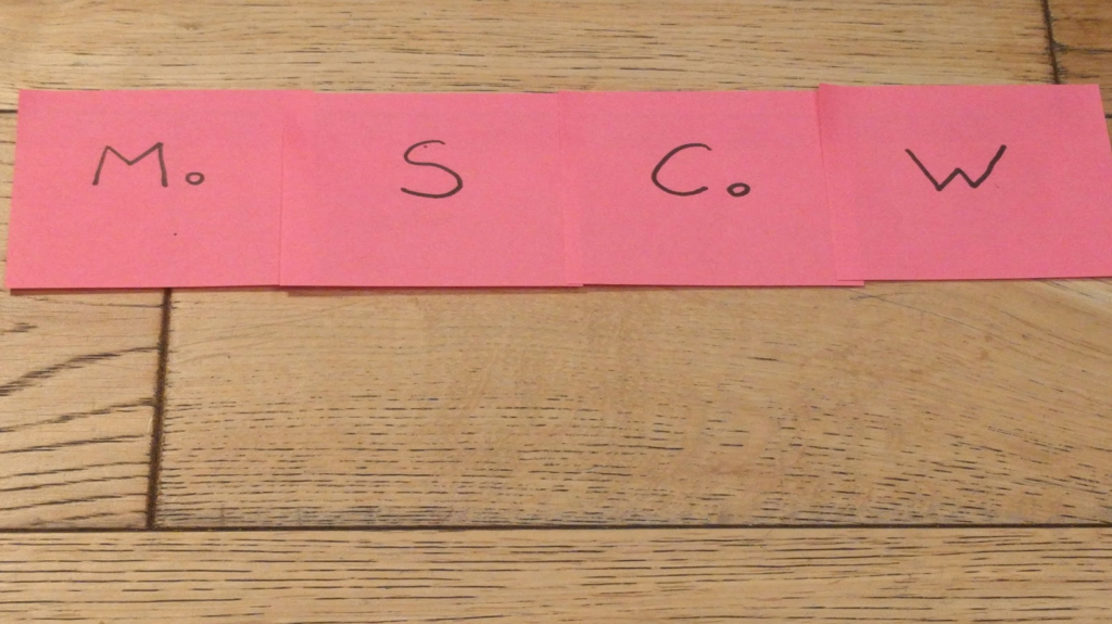 Post-its next to each other near the top of a photo of a wooden floor:
Mo, S, Co, W.