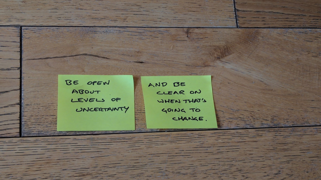 Photo of post-its on a wooden floor:

"Be open about levels of uncertainty"
"And be clear on when that's going to change"
