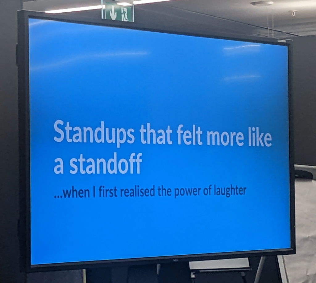 Slide on a big screen: "Standups that felt more like a standoff ...when I first realised the power of laughter"