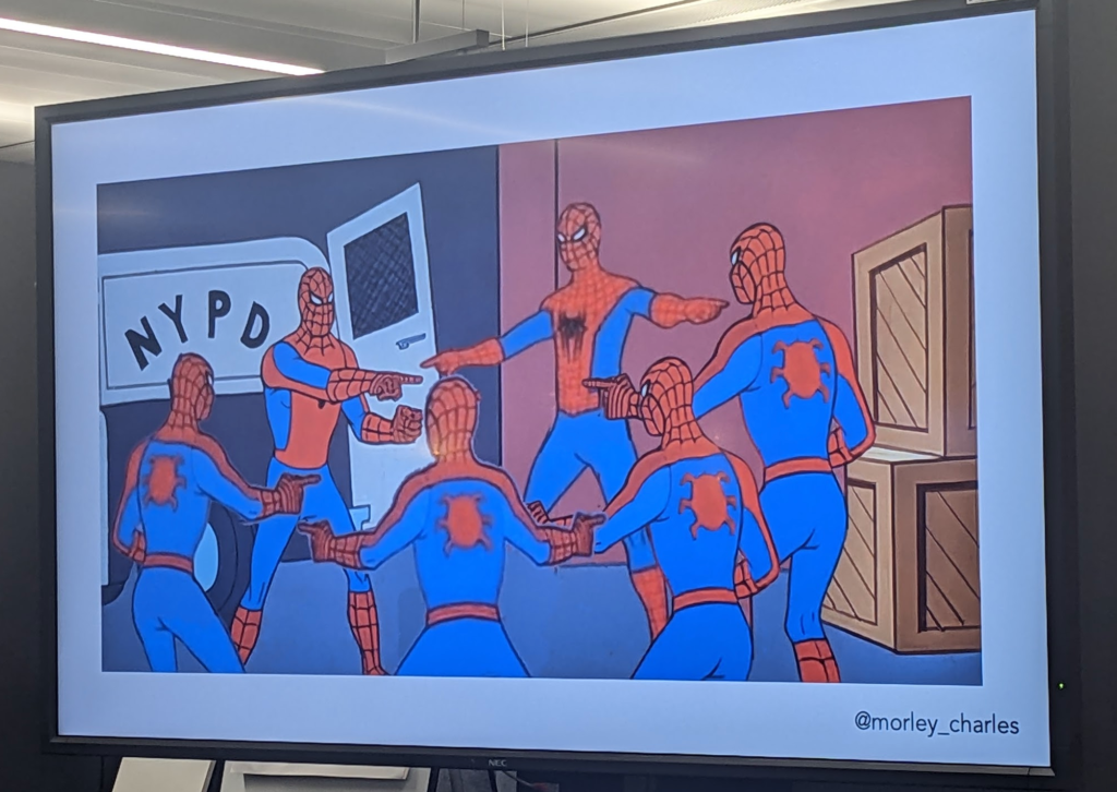Slide showing 6 spider-men all pointing at each other in a circle. It's an edited version of a photo with just 2 spider-men.