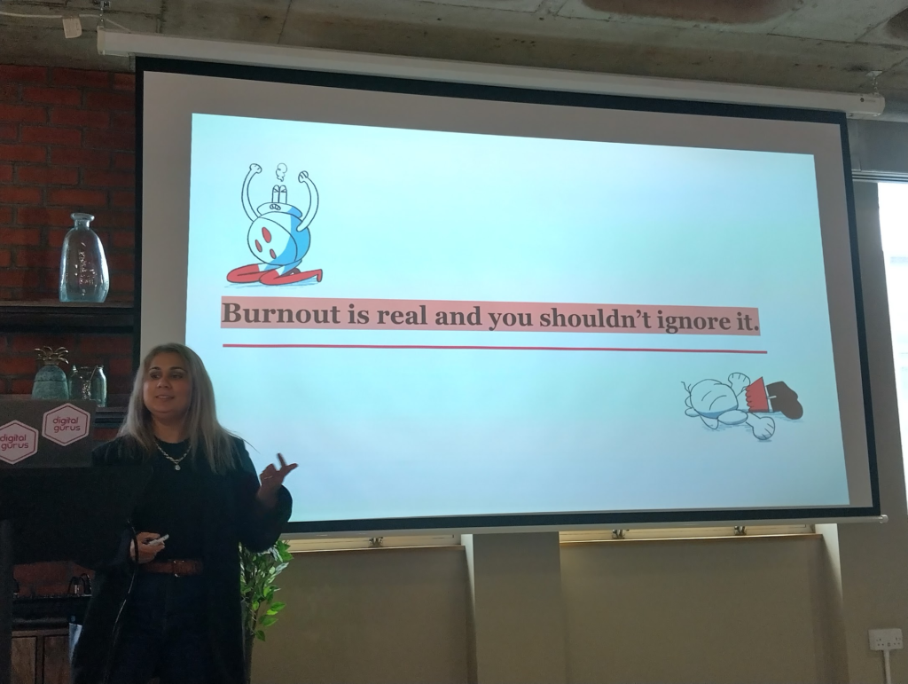 Photo of Vivi in front of one of her slides: "Burnout is real and you shouldn't ignore it"