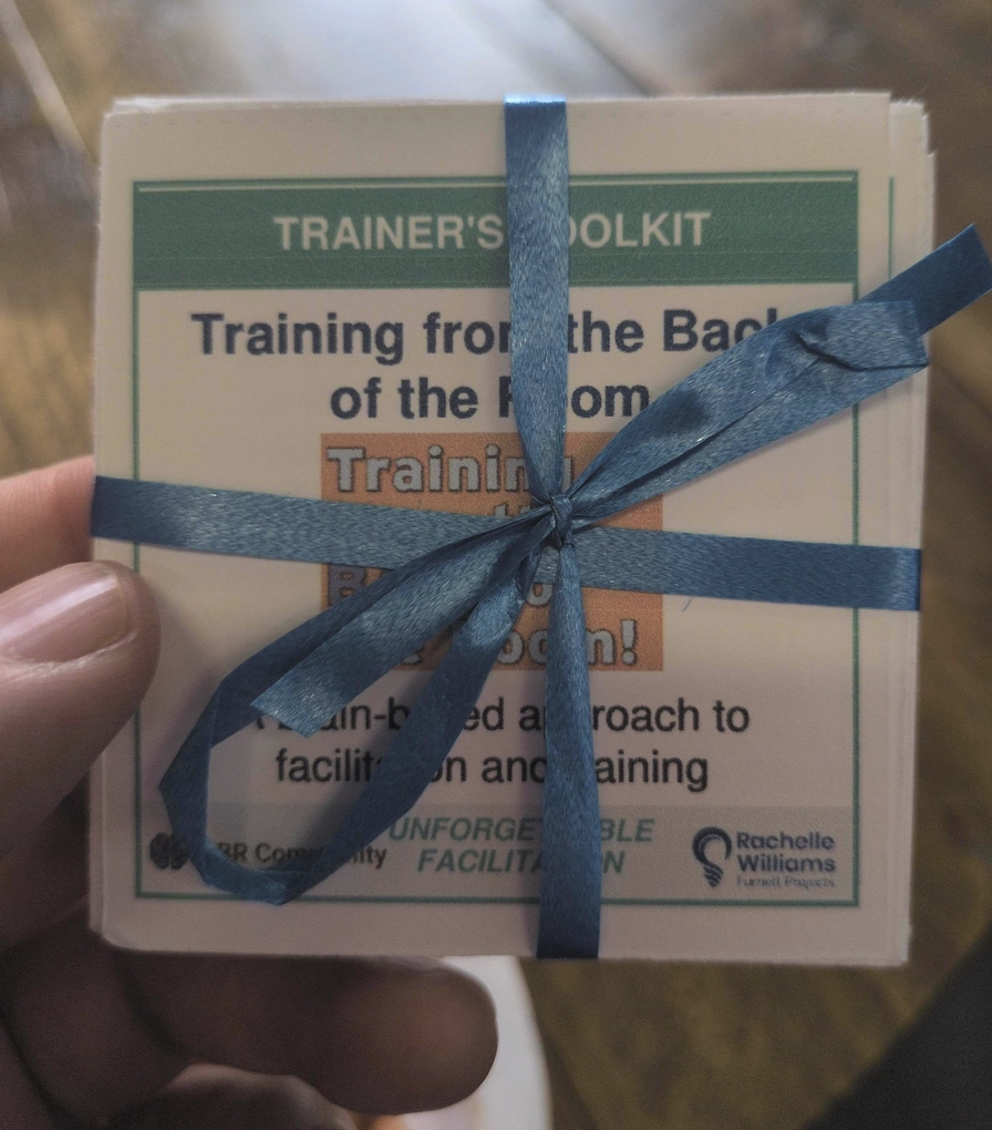 A set of cards wrapped with a blue ribbon. It has the "training from the back of the room" logo on it.