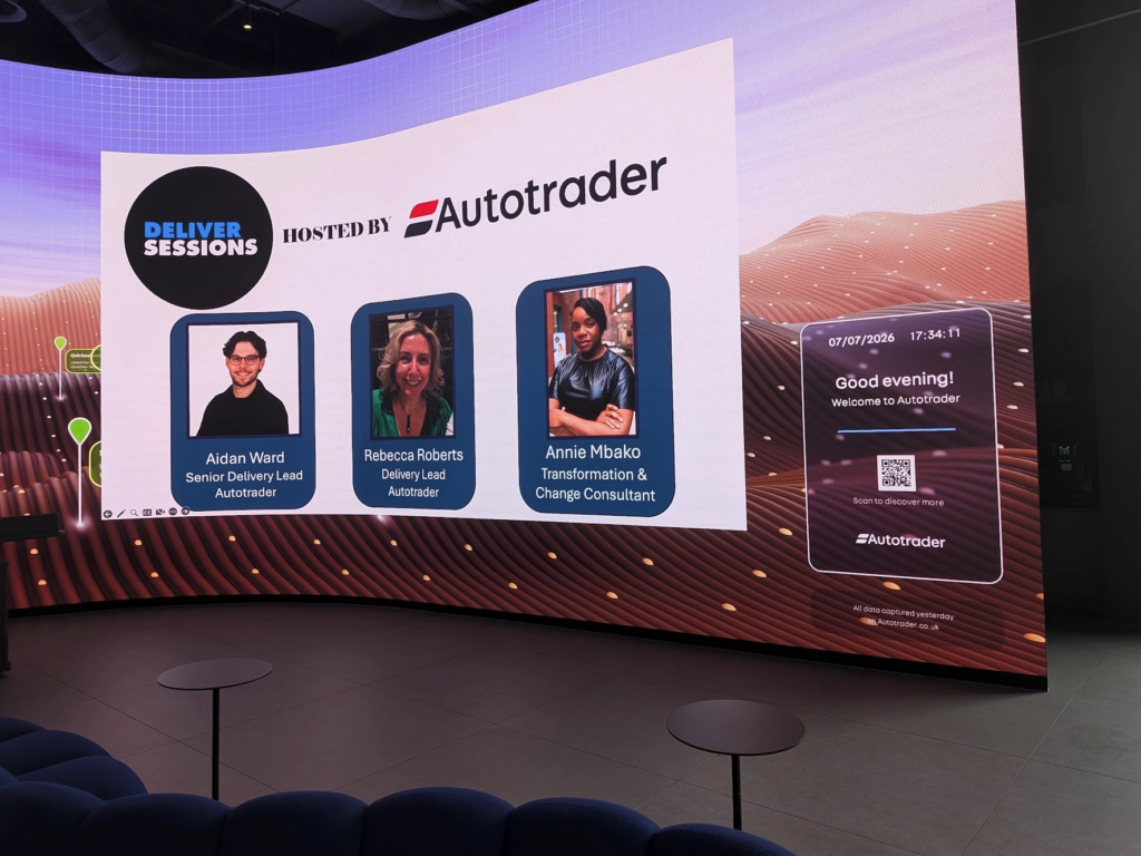 Photo of the huge curved screen. "Deliver Sessions hosted by Autotrader" is at the top, with photos of the 3 speakers below.